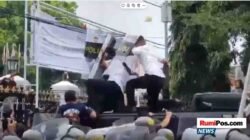 Bupati Pati, Sudewo, berlindung di balik tameng aparat saat massa aksi melempari dengan batu dan berbagai benda dalam unjuk rasa di depan Kantor Bupati Pati, Rabu (13/8/2025)